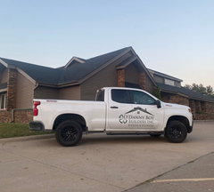 O’Danny Boy truck parked at a residential roof replacement project, outside a home with brown siding and dark gray shingles